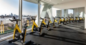 A wide-angle shot of a spacious, well-equipped gym with rows of weight machines and free weights.